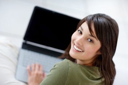 Portrait of a happy young female using a laptop